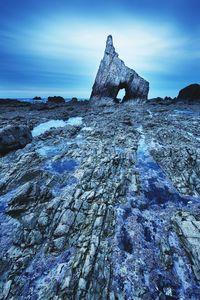 Rock formations on land against blue sky