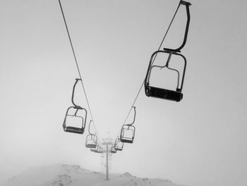 Low angle view of overhead cable car against sky during winter