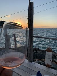 Glass of sea against sky during sunset