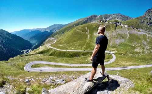 Man standing on rock against mountain road