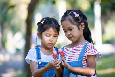Cute girls holding popsicles at park