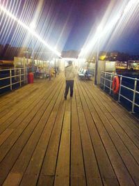 Full length of woman standing in illuminated room