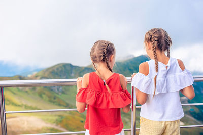 Rear view of women standing against sky