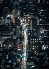 Aerial view of illuminated buildings and road in city at night
