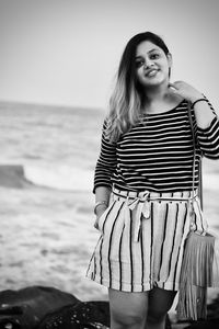 Portrait of woman standing at beach