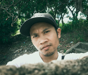 Portrait of young man against trees
