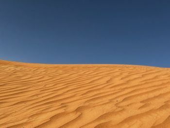 Scenic view of sand dunes against clear sky