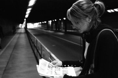 Side view of woman in bus at night