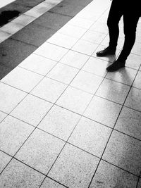 Low section of people standing on tiled floor