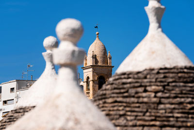 Trulli rooftops with bell tower in the background
