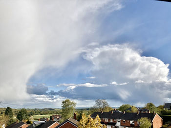 Panoramic view of houses and trees against sky