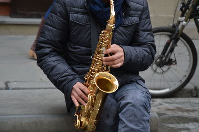 Midsection of man playing music in city