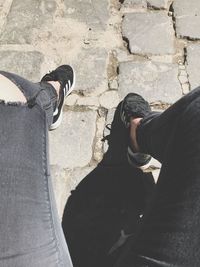 Low section of man standing on cobblestone