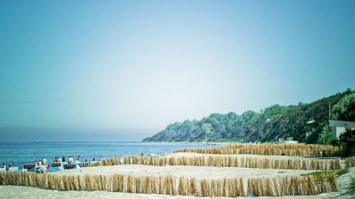 People at beach against blue sky