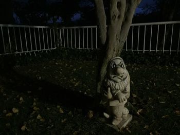 Statue against trees at night