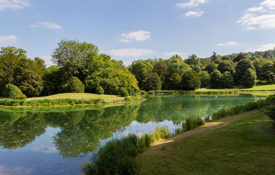 Scenic view of lake by trees against sky