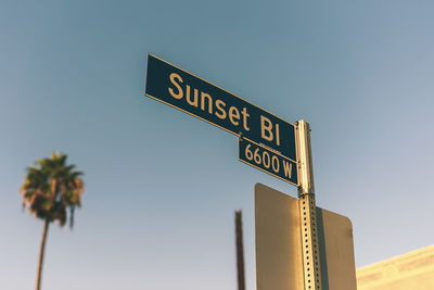 Low angle view of road sign against clear sky