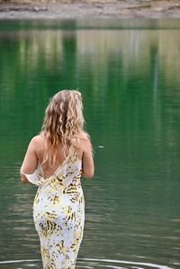 Rear view of woman standing in lake