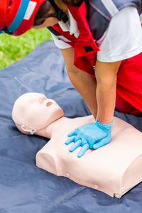 Healthcare worker practicing on cpr dummy at park