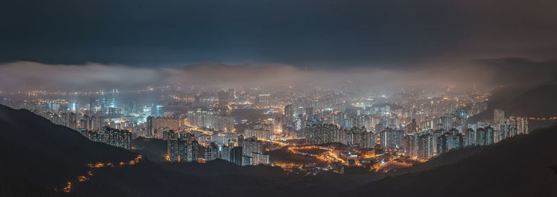 Illuminated cityscape against sky at night