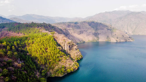 High angle view of sea and mountains against sky