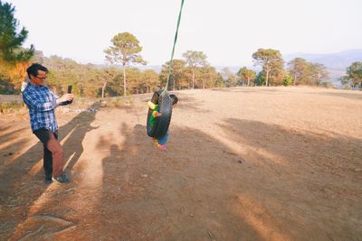 Cinematic view of a girl playing on a tyre swing 