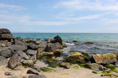 Rocks on beach against sky