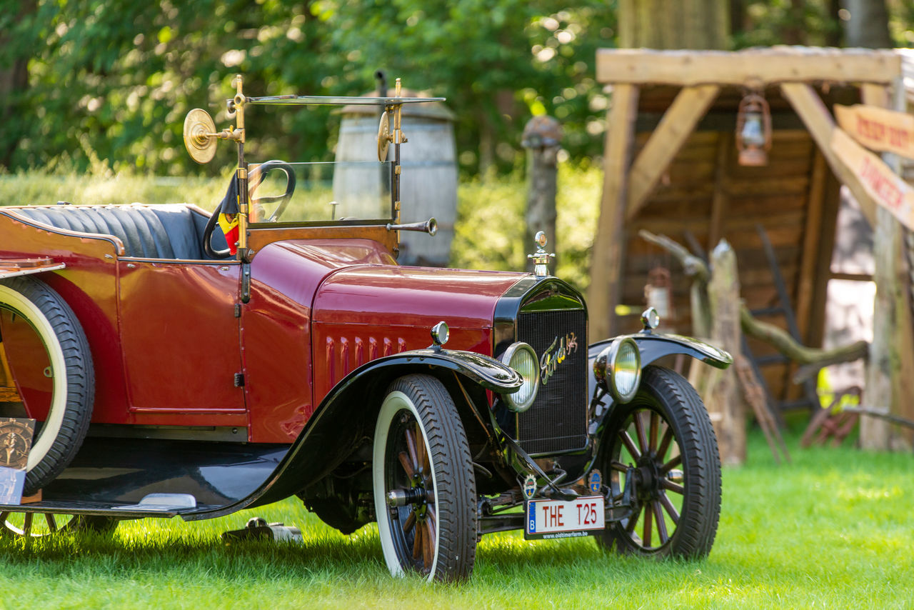 car, land vehicle, vehicle, transportation, mode of transportation, vintage car, antique car, retro styled, grass, plant, nature, touring car, motor vehicle, day, outdoors, travel, no people, green, luxury vehicle, architecture