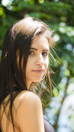 Close-up portrait of young woman against tree