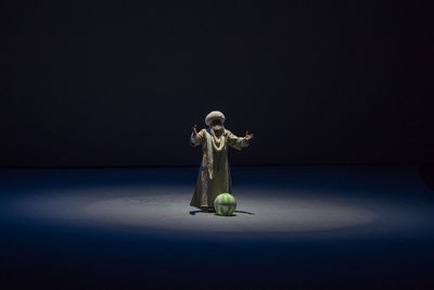 Buddha statue on table against black background