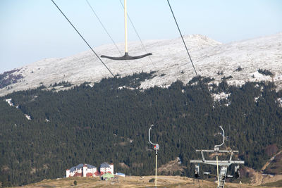 Ski lift over the mountains against the sky and hotels zone for winter tourism