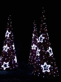 Close-up of illuminated christmas tree against black background