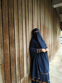 Rear view of man standing against wall