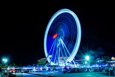 Illuminated ferris wheel in city at night