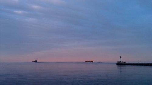 Boat sailing in sea at sunset