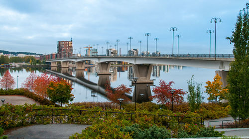 Bridge over river in city against sky