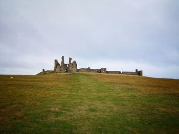 Built structure on field against sky