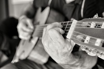 Midsection of man playing guitar