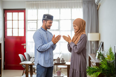 Smiling woman greeting with guest at home