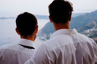 Rear view of couple looking at mountain against sky