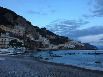 Buildings by sea against sky in city