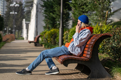 Portrait of woman sitting on footpath