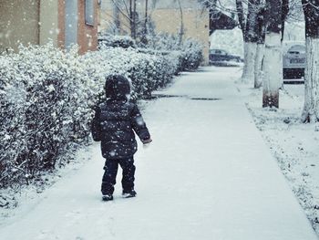 Woman walking on snow covered landscape