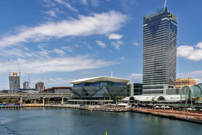 Buildings by river against sky