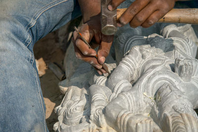Midsection of man working on sculpture