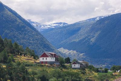 Houses by mountains against sky