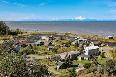 High angle view of houses by sea against sky