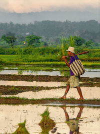 Full length of person with umbrella at farm