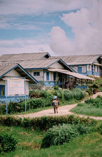 People walking on field against sky