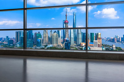 View of buildings against sky seen through glass window